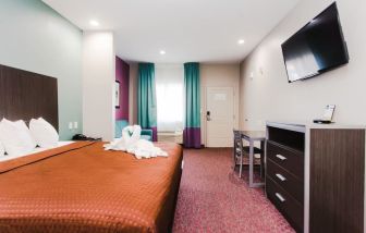 King bed with TV and natural light at Express Inn - Spring.