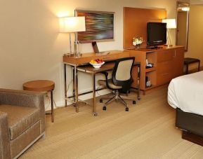 King bed with couch and work space at EnVision Hotel And Conference Center Mansfield Foxboro.