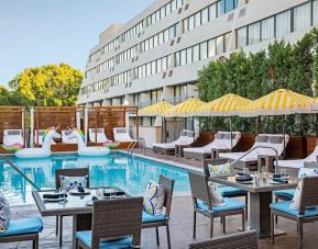 Outdoor pool with surrounding seating area at Hotel Dena, Pasadena Los Angeles.