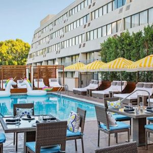 Outdoor pool with surrounding seating area at Hotel Dena, Pasadena Los Angeles.