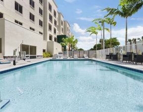 Outdoor pool with chairs at Hampton Inn & Suites Miami Kendall. 