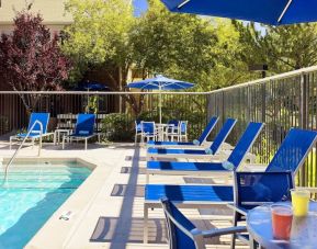 Outdoor pool and pool chairs at Sonesta ES Suites Auburn Hills Detroit.