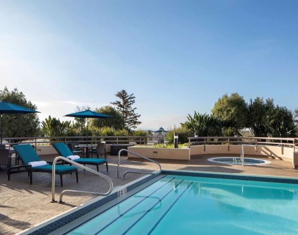 Outdoor pool with seating area at Sonesta San Jose.