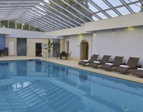 Indoor pool with seating area at DoubleTree By Hilton Oxford Belfry.