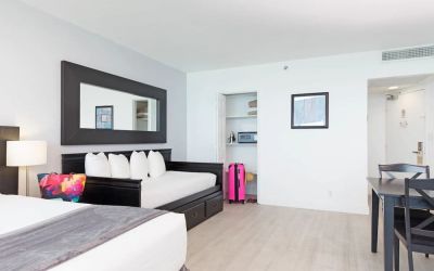 Day room with king bed and lounge chair at New Point Miami.