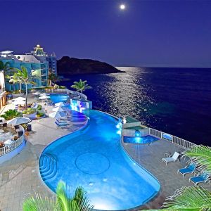 Aerial nighttime angle of lit up Infinity Pool at Oyster Bay Resort in St. Maarten.