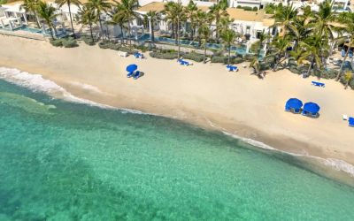 Oyster Bay Resort's beach with sun tanning chairs and waves going on shore. 