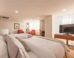 Romantic king room with natural light at Suites Perisur Furnished Apartments.