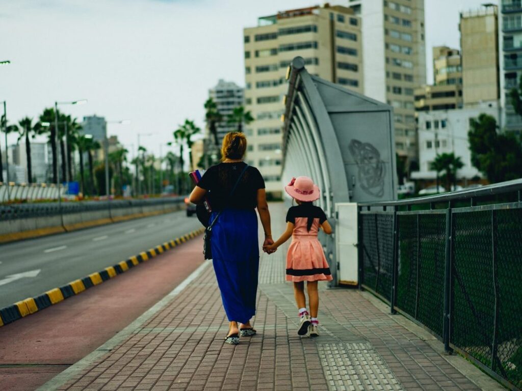 mother and daughter walking along a water front path
