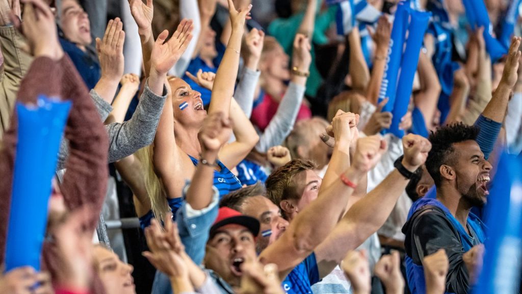 best places to watch sports in a stadium: cheering fans dressed in blue at a sports stadium
