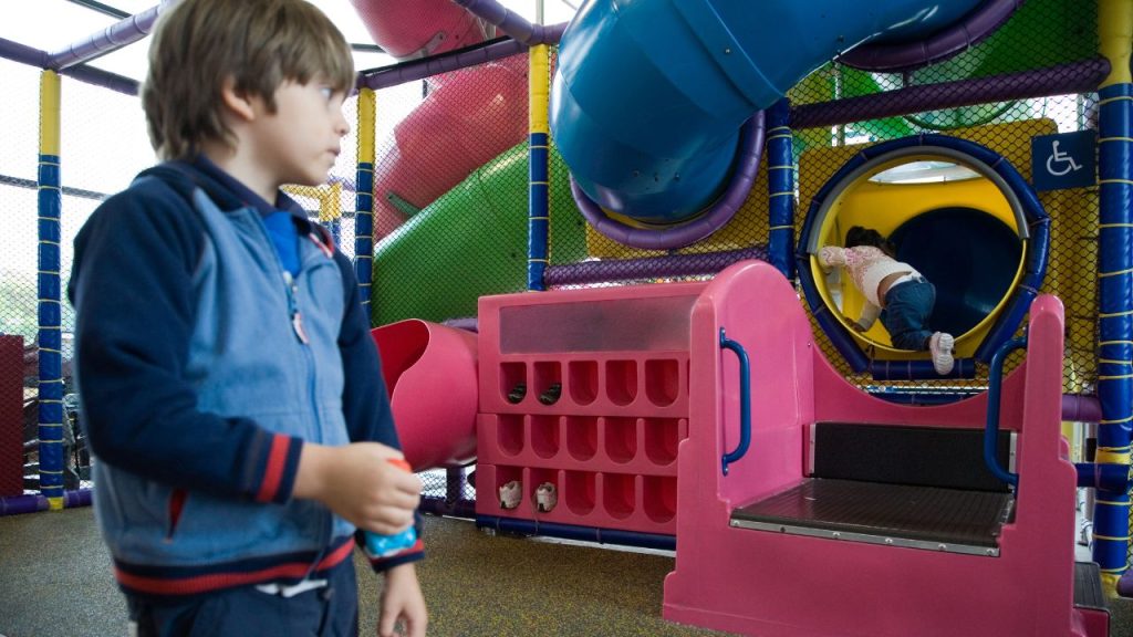 kids indoor-recreation area: young boy in blue jacket entering play area
