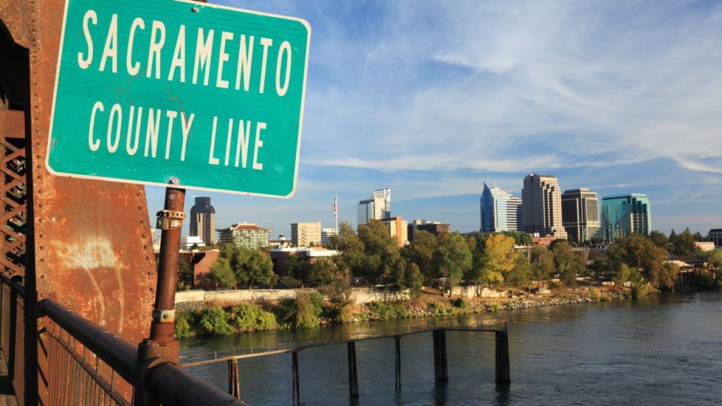 sacramento california county line signage with city skyline in the background
