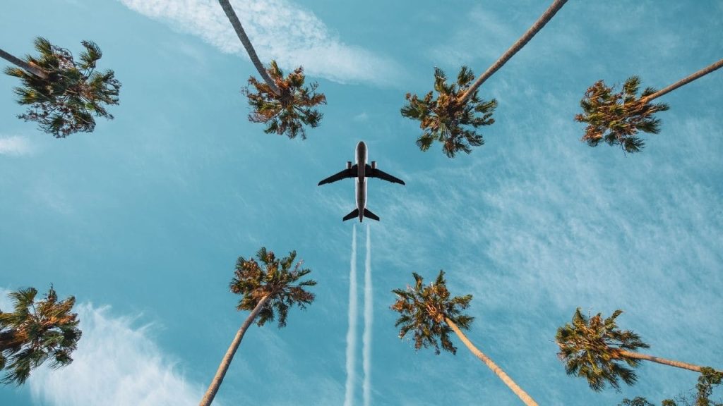 airplane taking off from tropical destination
