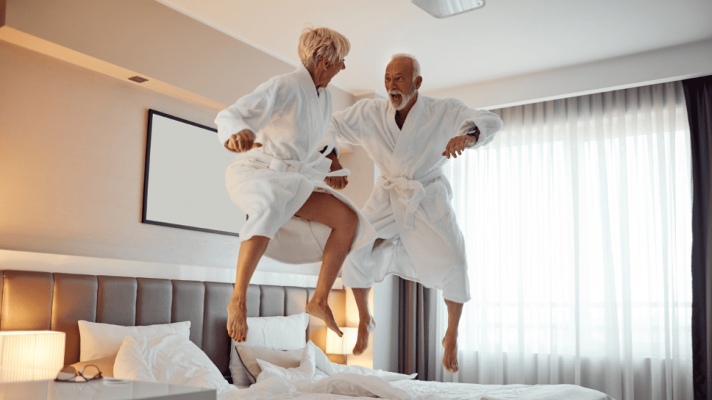 senior couple jumping on bed