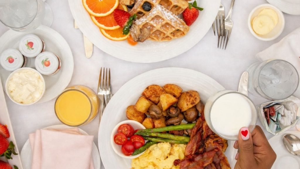 Valentines day hotel room service breakfast spread for two with waffles and eggs