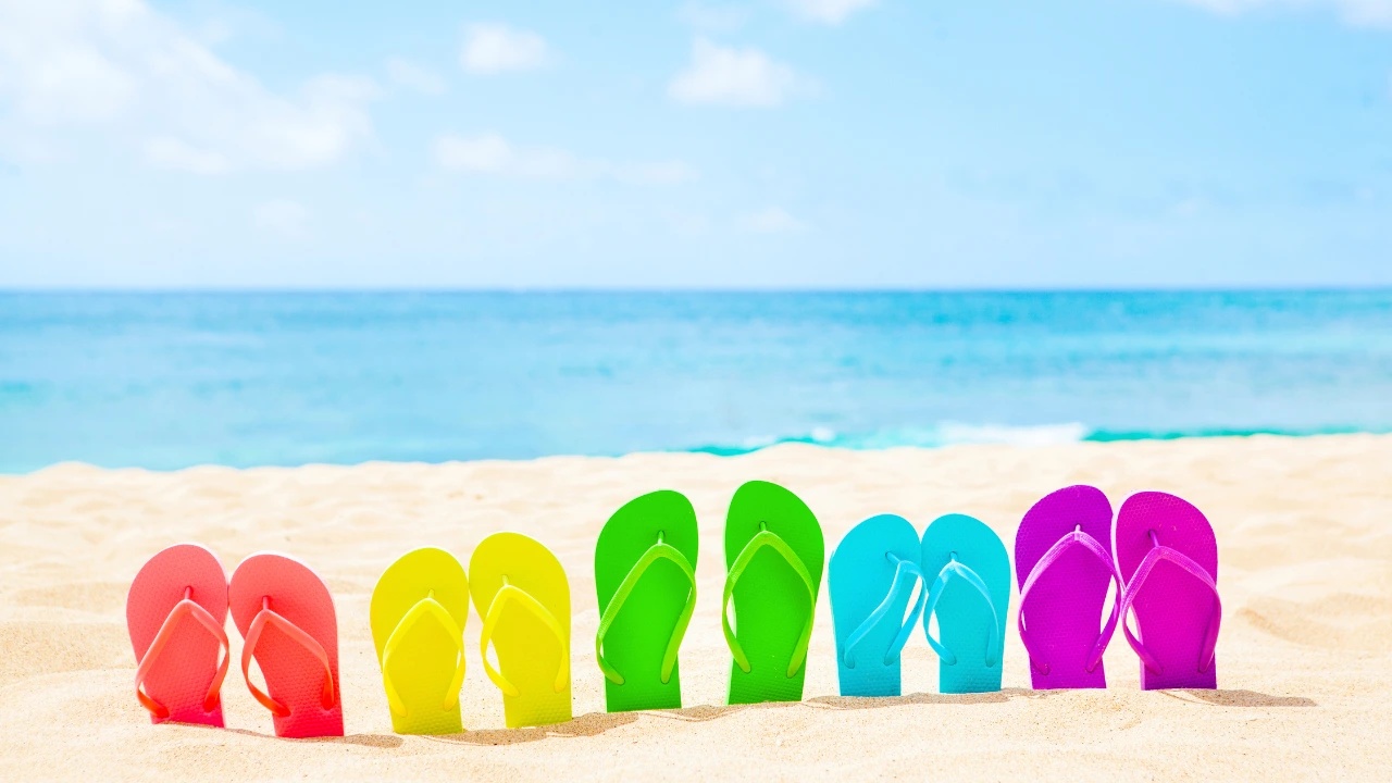 best spring break destinations: multi-colored flip flops in sand