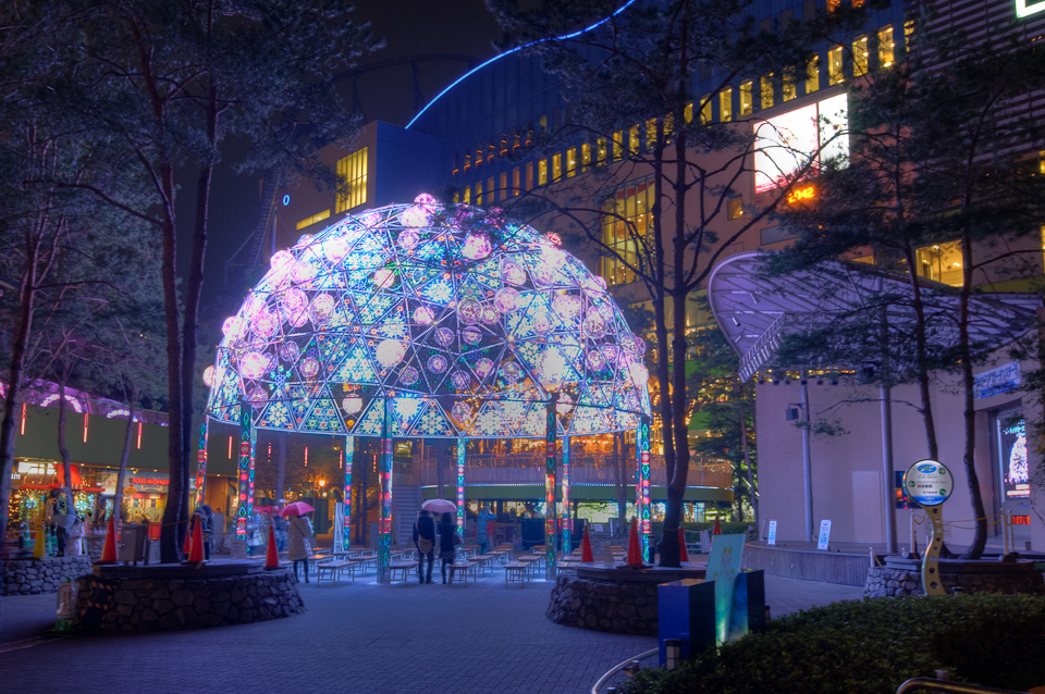 Bright fairy lights over dome in Tokyo public space.