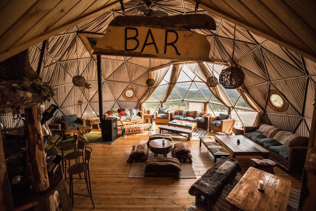 Expansive interior of dome with large "Bar" sign and various types of lounge seating.