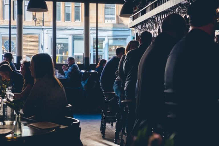 People sitting closely inside bar and restaurant.