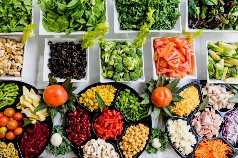 A platter of healthy food, broccoli, tomatoes, carrots, greens and more!