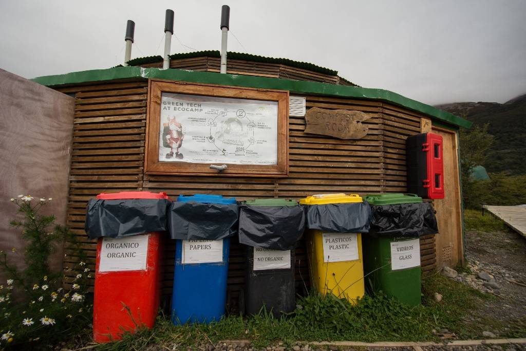 Red, blue, black, yellow and green recycling and compost cans at EcoCamp Patagonia.