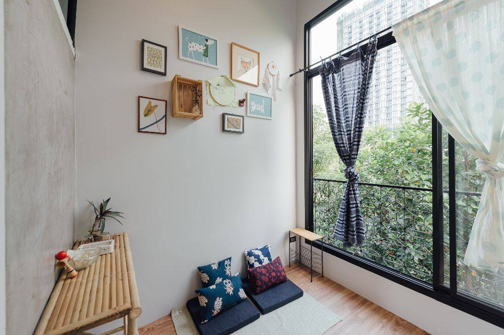 Room with neatly tied curtain and bright light filling in from the window.