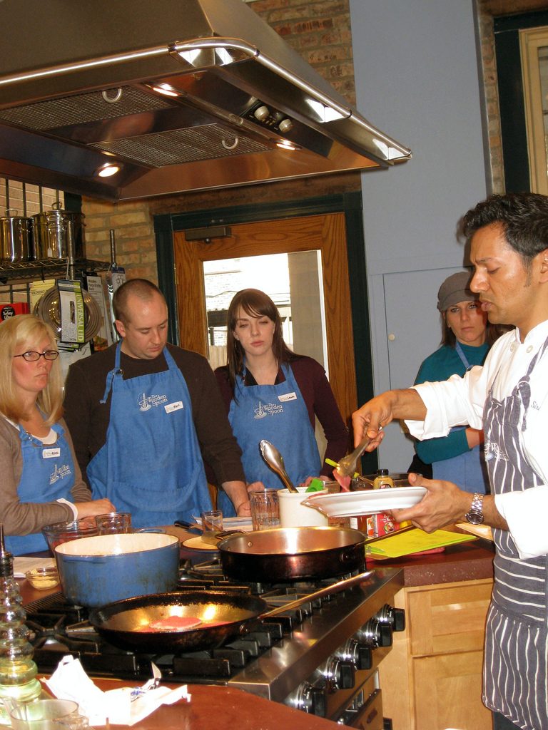 People watch chef in cooking class.