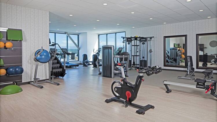 Airy and bright gym with weight machines, stairmasters, bicycle machines.