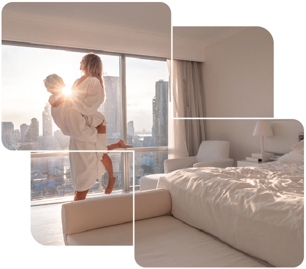 a couple in robes on a bed with a view of the city